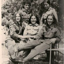 five women sit close together
